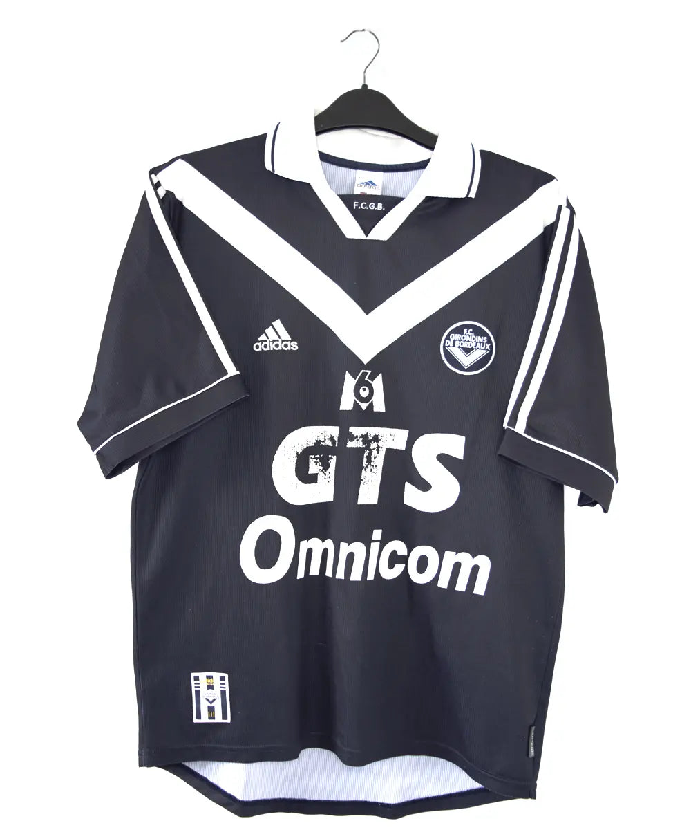 Maillot domicile des girondins de bordeaux édité lors de la saison 1999 2000. Le maillot est de couleur bleu et blanc. On peut retrouver l'équipementier adidas et le sponsor M6 GTS Omnicom