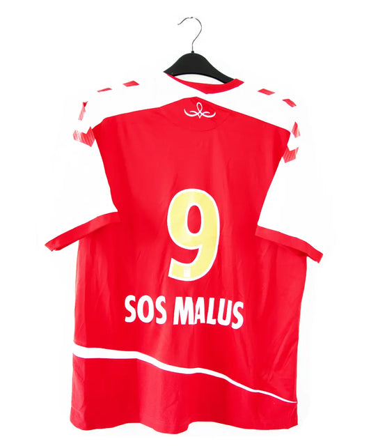 Maillot domicile du stade de reims de la saison 2015-2016. Le maillot est de couleur rouge et blanche. On peut retrouver le sponsir sanei ascenseur, le sponsor caillot, le sponsor geodis et l'équipementier hummel