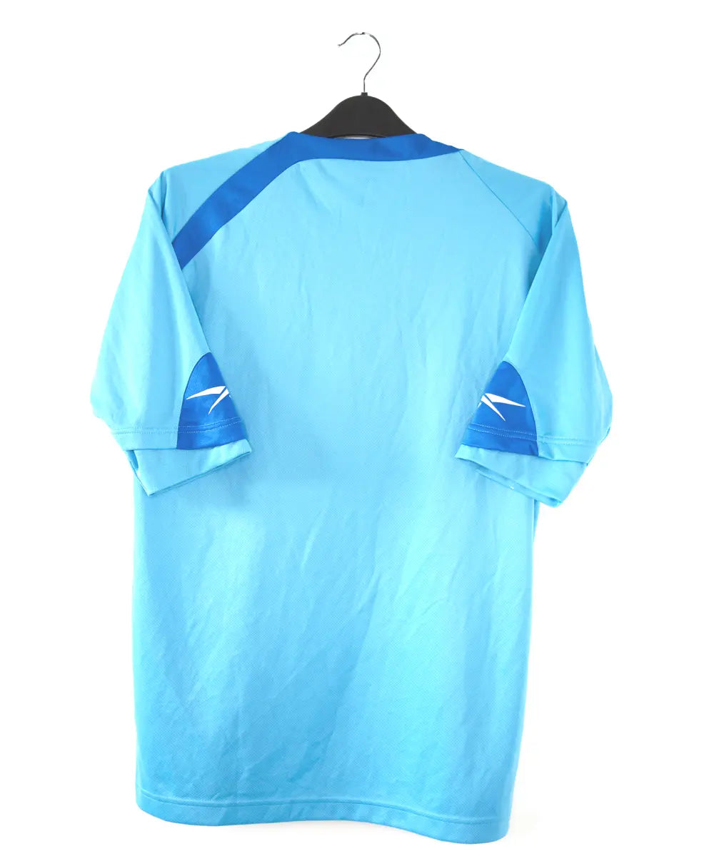 Maillot extérieur du rc lens lors de la saison 2009-2010. Le maillot est de couleur bleu. On retrouve l'équipementier rebok et le sponsor invicta