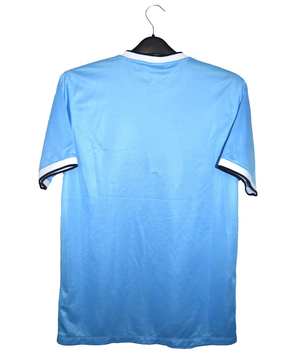 Maillot domicile de dos porté par manchester city lors de la saison 2013-2014. On peut retrouver l'équipementier nike et le sponsor etihad