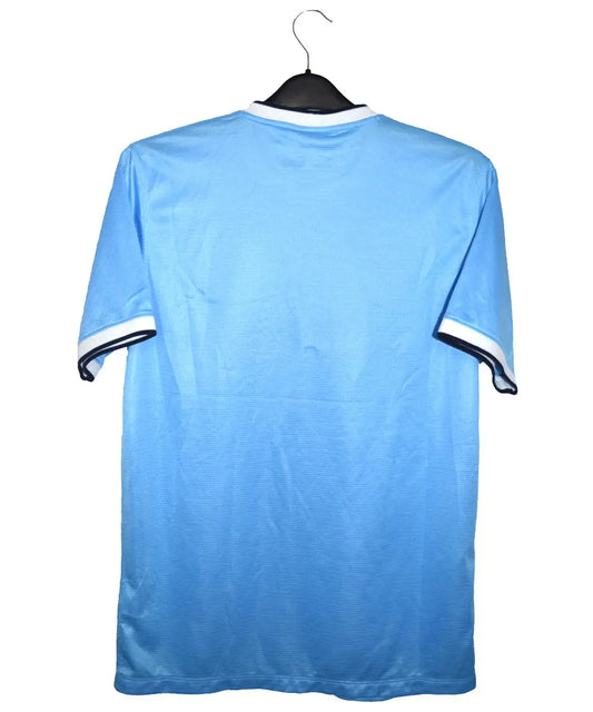 Maillot domicile de dos porté par manchester city lors de la saison 2013-2014. On peut retrouver l'équipementier nike et le sponsor etihad