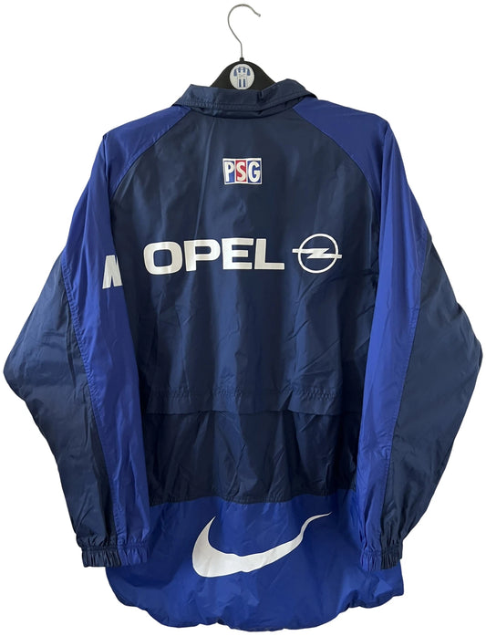 Veste bleue du PSG de la saison 1998/1999. On peut retrouver l'équipementier Nike et le sponsor Opel. Il s'agit d'une veste authentique d'époque.