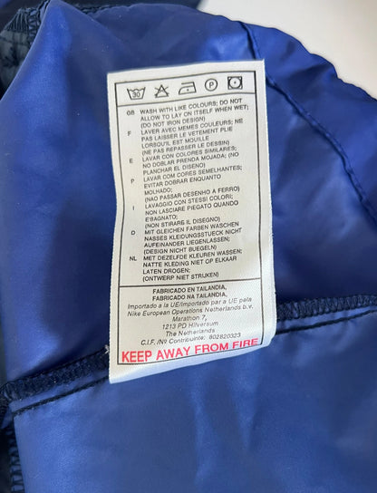 Veste bleue du PSG de la saison 1998/1999. On peut retrouver l'équipementier Nike et le sponsor Opel. Il s'agit d'une veste authentique d'époque.