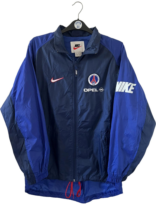 Veste bleue du PSG de la saison 1998/1999. On peut retrouver l'équipementier Nike et le sponsor Opel. Il s'agit d'une veste authentique d'époque.