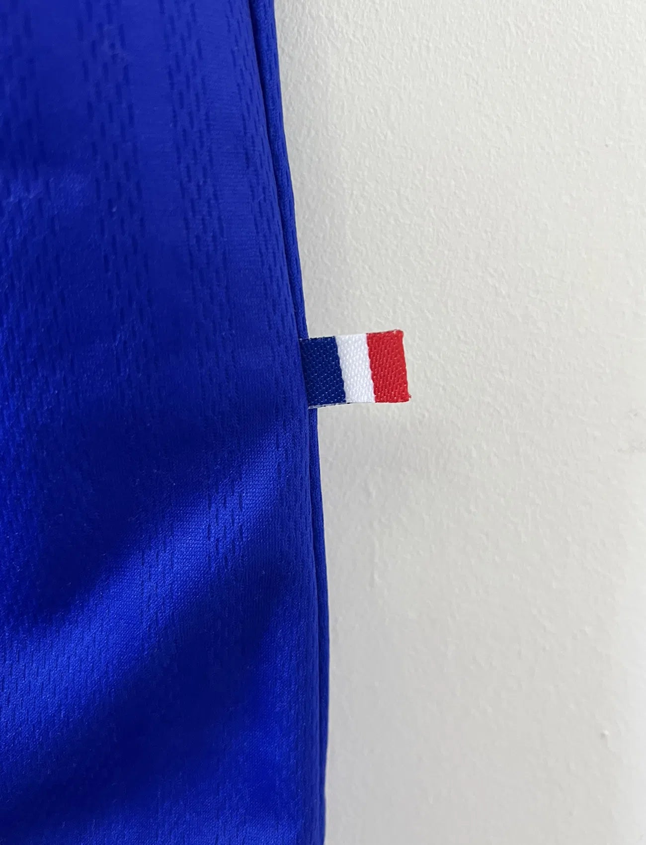 Maillot de foot vintage de l'équipe de france 98 bleu blanc et rouge. On peut retrouver l'équipementier adidas et le coq avec l'étoile. Il s'agit d'un maillot authentique édité lors de la coupe du monde 1998.