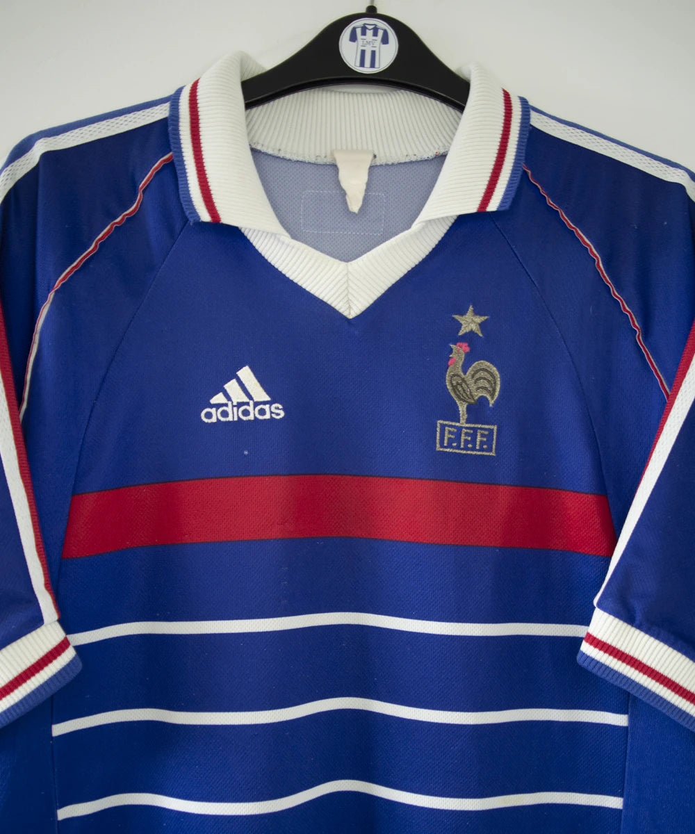 Maillot de foot vintage bleu blanc et rouge de l'équipe de france 1998. On peut retrouver l'équipementier adidas. Il s'agit d'un maillot authentique d'époque