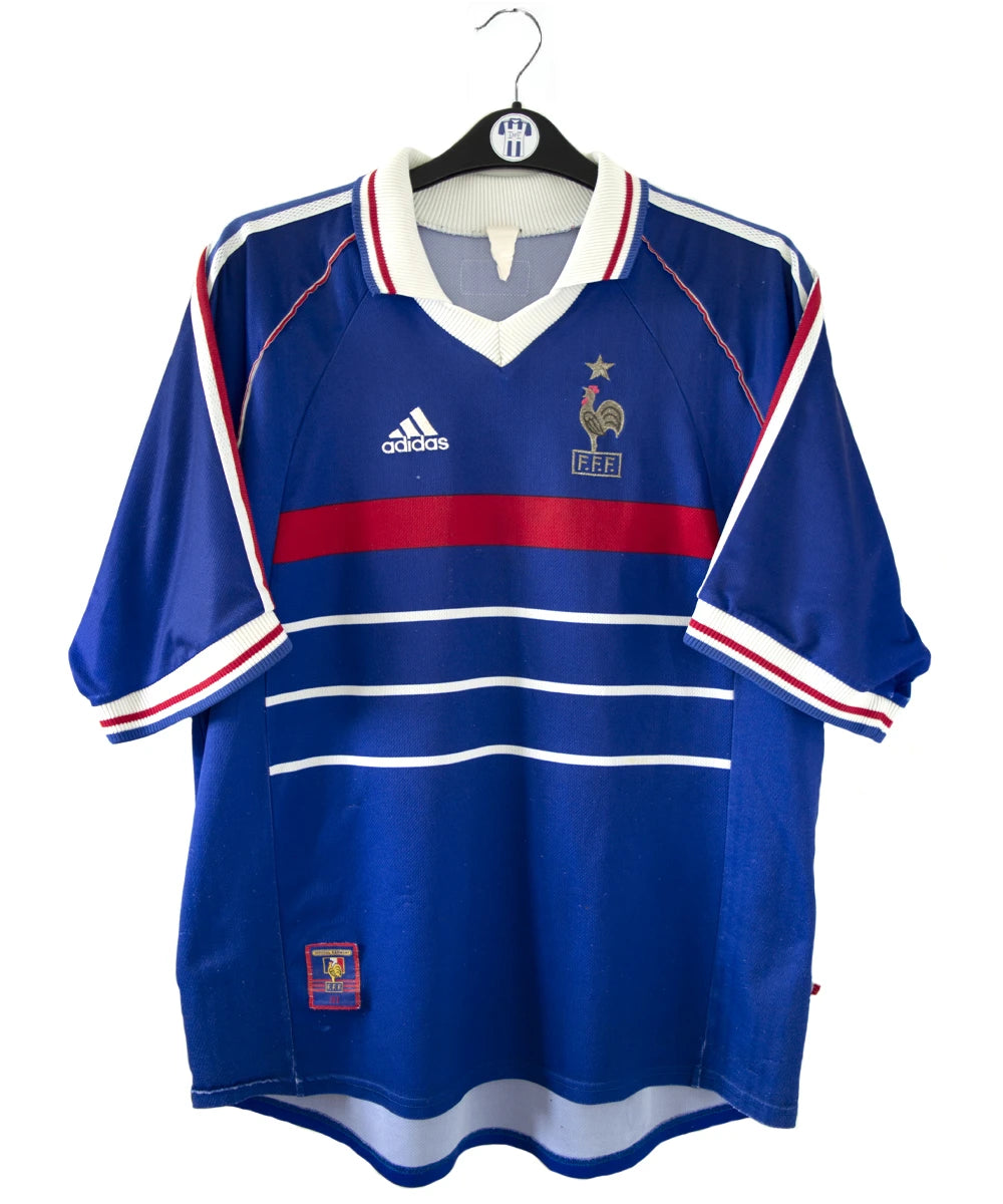 Maillot de foot vintage bleu blanc et rouge de l'équipe de france 1998. On peut retrouver l'équipementier adidas. Il s'agit d'un maillot authentique d'époque
