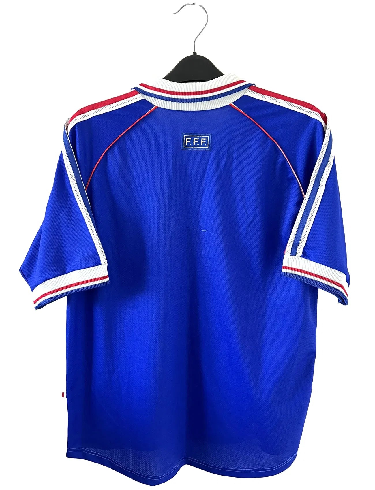 Maillot de foot vintage bleu blanc et rouge domicile de l'équipe de France 1998. On peut retrouver le sponsor adidas. On peut voir le coq avec l'étoile avec la signature "pour toi" de Zinedine Zidane. Il s'agit d'un maillot authentique.