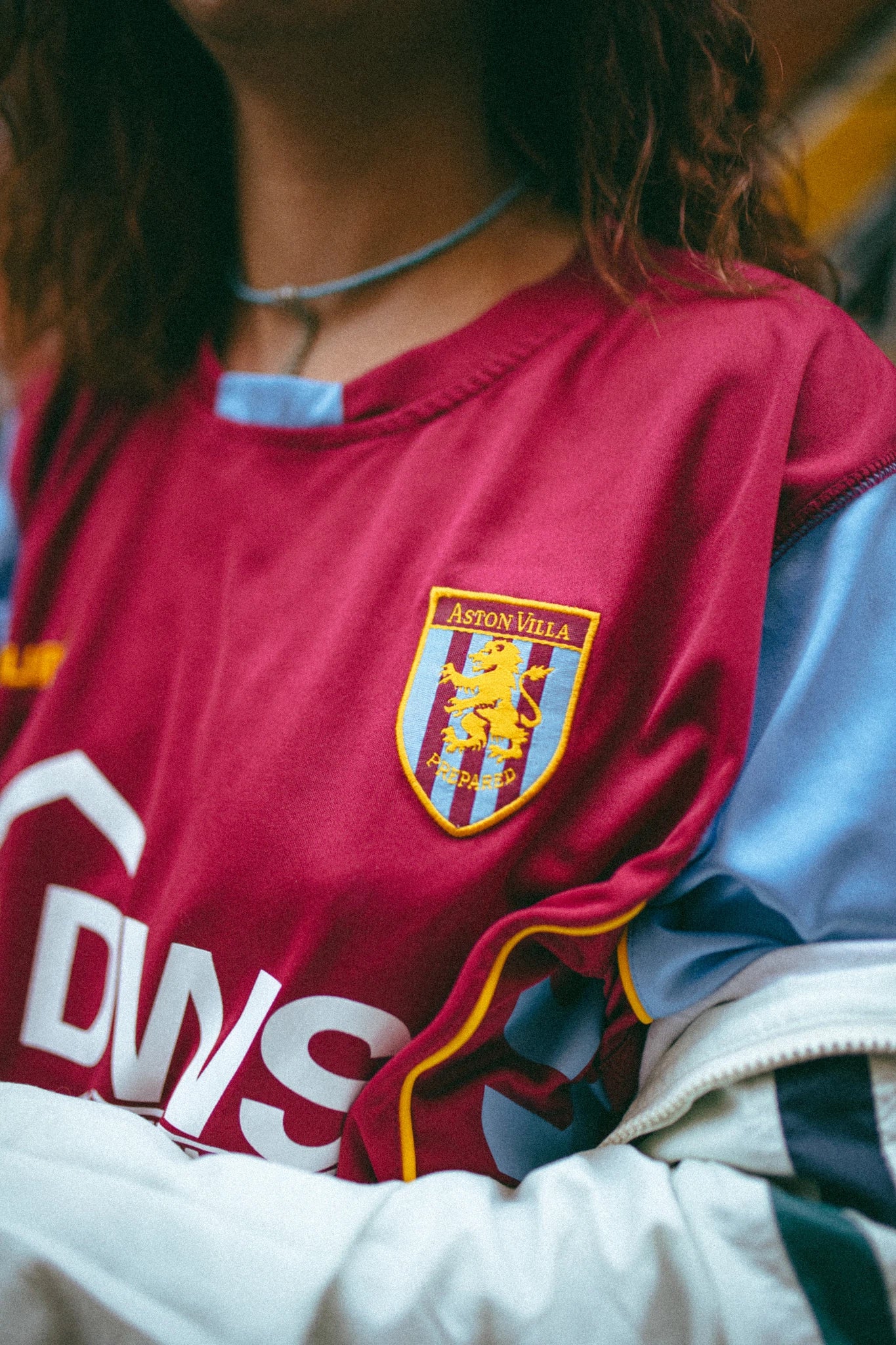 Sur cette photo on peut voir une femme portant un maillot de foot vintage rouge d'aston villa