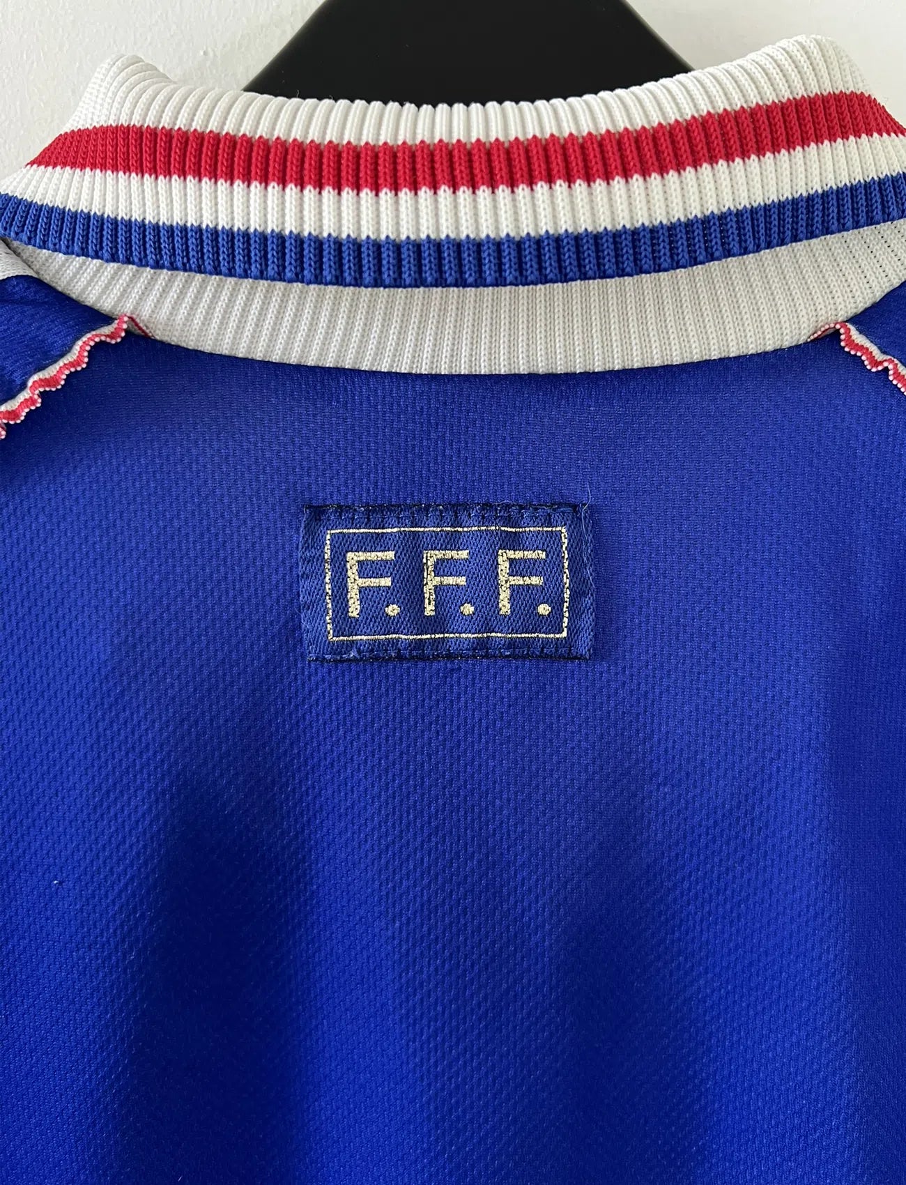 Maillot de foot vintage de l'équipe de france 98 bleu blanc et rouge. On peut retrouver l'équipementier adidas et le coq avec l'étoile. Il s'agit d'un maillot authentique édité lors de la coupe du monde 1998.