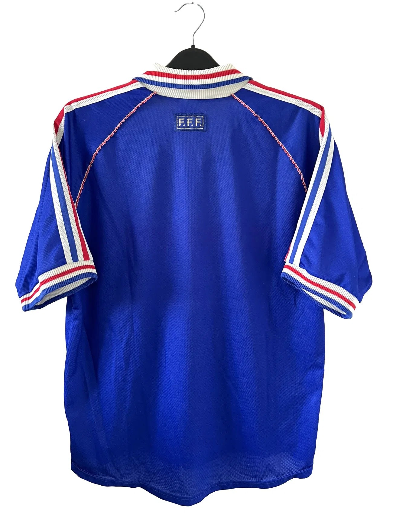 Maillot de foot vintage de l'équipe de france 98 bleu blanc et rouge. On peut retrouver l'équipementier adidas et le coq avec l'étoile. Il s'agit d'un maillot authentique édité lors de la coupe du monde 1998.