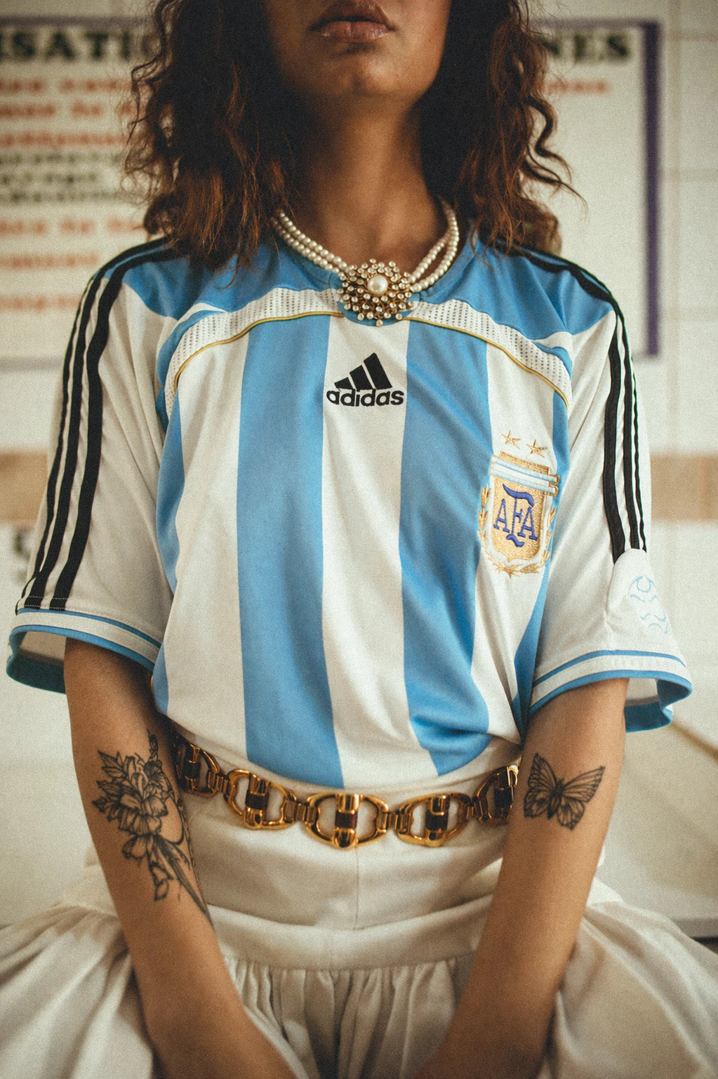 Sur cette photo on peut voir une femme portant un maillot de foot vintage de l'argentine.