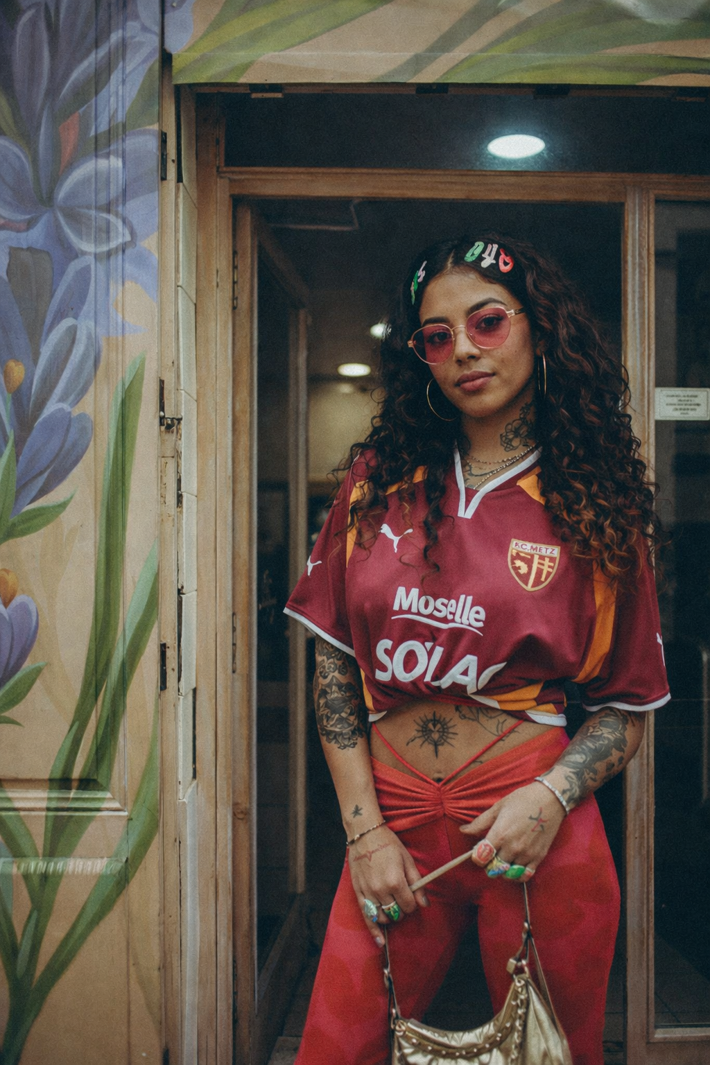 Photo de la collection  nos maillots vintage de Ligue 1 du site Le Maillots vintage. On peut y voir une femme portant fièrement un maillot du FC Metz