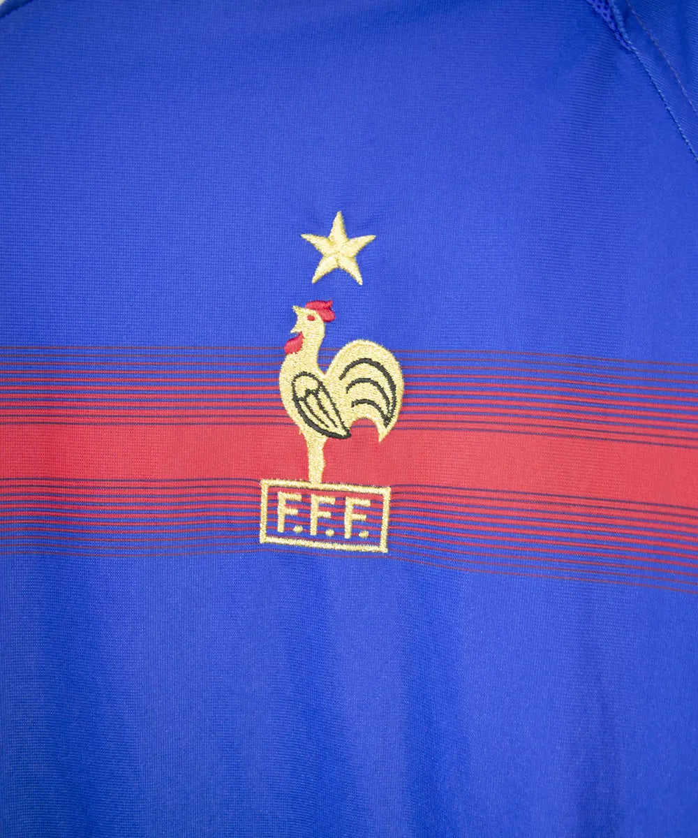 Maillot bleu blanc et rouge de l'équipe de france 2004. On peut retrouver l'équipementier adidas