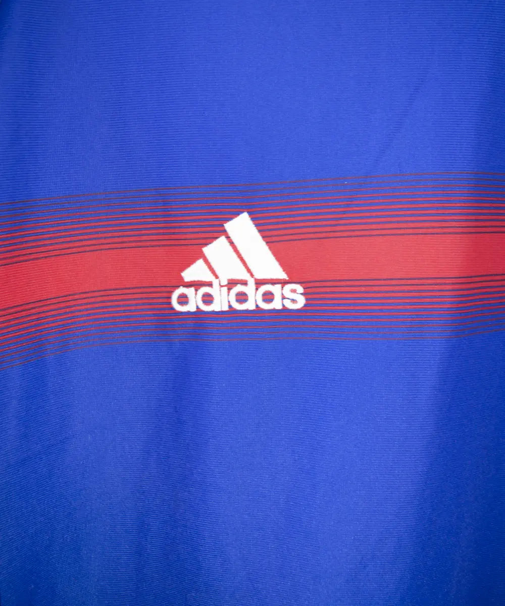 Maillot bleu blanc et rouge de l'équipe de france 2004. On peut retrouver l'équipementier adidas