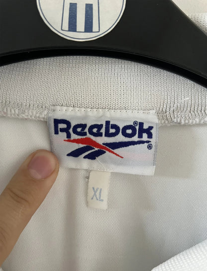 Maillot de foot vintage extérieur blanc du SC Bastia saison 1996/1997. On peut retrouver l'équipementier Reebok et le sponsor Nouvelles Frontières. Il s'agit d'un maillot authentique d'époque.