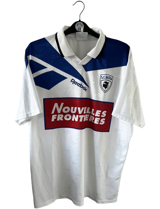 Maillot de foot vintage extérieur blanc du SC Bastia saison 1996/1997. On peut retrouver l'équipementier Reebok et le sponsor Nouvelles Frontières. Il s'agit d'un maillot authentique d'époque.