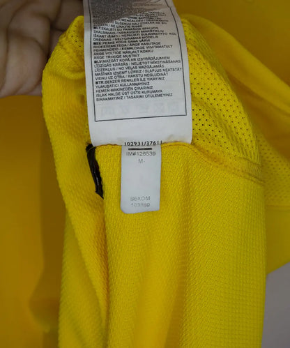 Maillot domicile jaune et vert du brésil 2006-2008. On peut retrouver l'équipementier nike. Le maillot est floqué du numéro 9 Ronaldo. Sur cette photo on peut voir l'étiquette d'authenticité comportant les numéros S6AOM