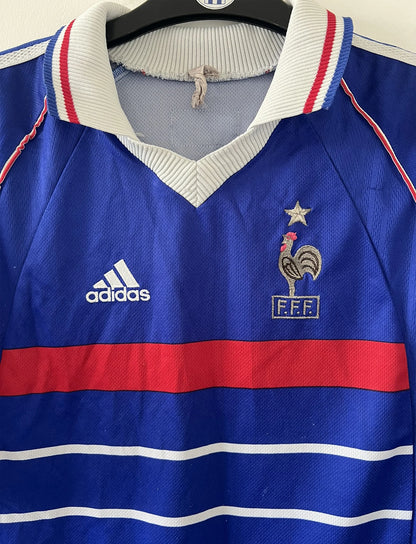 Maillot foot vintage domicile equipe de france 1998 bleu blanc et rouge. On peut retrouver l'équipementier adidas. Ils 'agit d'un maillot authentique d'époque floqué Zinedine Zidane