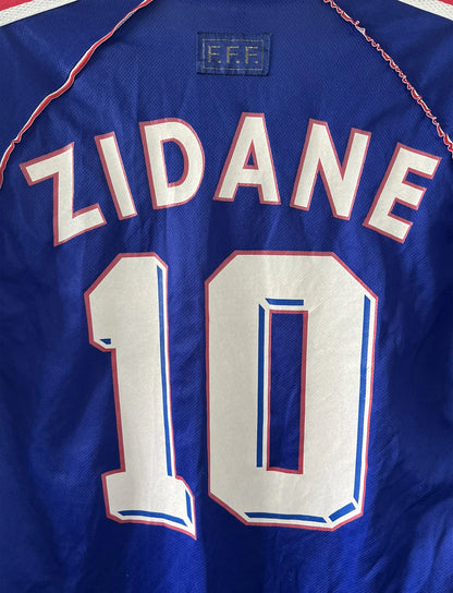 Maillot foot vintage domicile equipe de france 1998 bleu blanc et rouge. On peut retrouver l'équipementier adidas. Ils 'agit d'un maillot authentique d'époque floqué Zinedine Zidane
