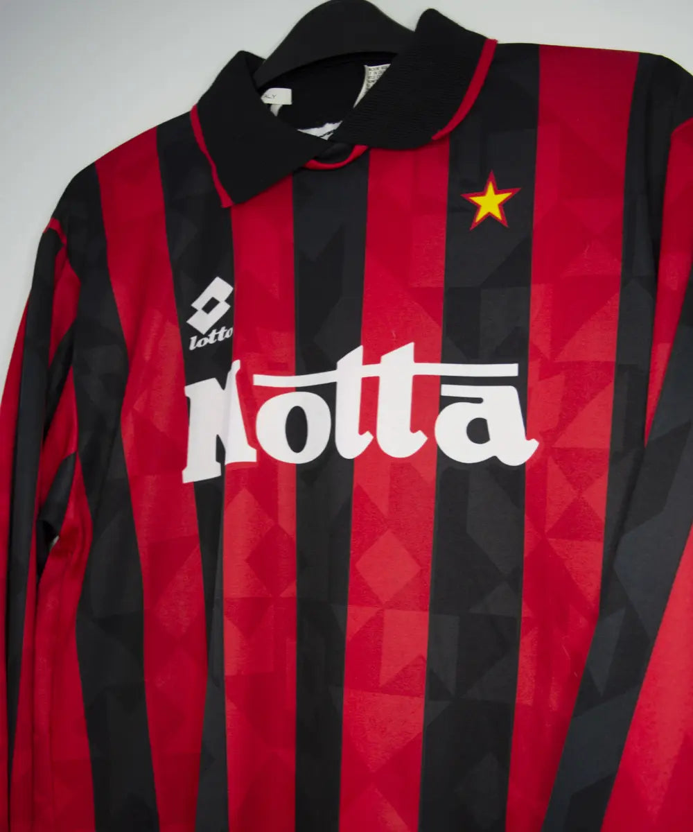 Maillot vintage domicile rouge et noir de l'AC Milan de la saison 1993-1994. On peut retrouver l'équipementier lotto et le sponsor motta