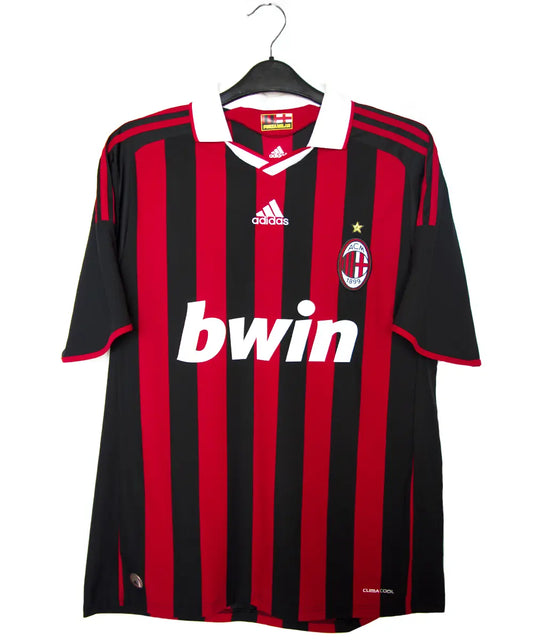 Maillot domicile noir et rouge de l'ac milan de la saison 2009-2010. On peut retrouver l'équipementier adidas et le sponsor bwin