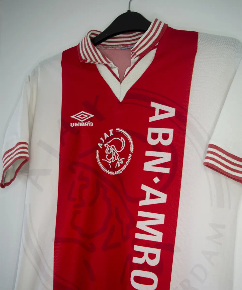 Maillot domicile de l'Ajax 1995-1996 de couleur rouge et blanc. On peut retrouver l'équipementier umbro et le sponsor ABN AMRO