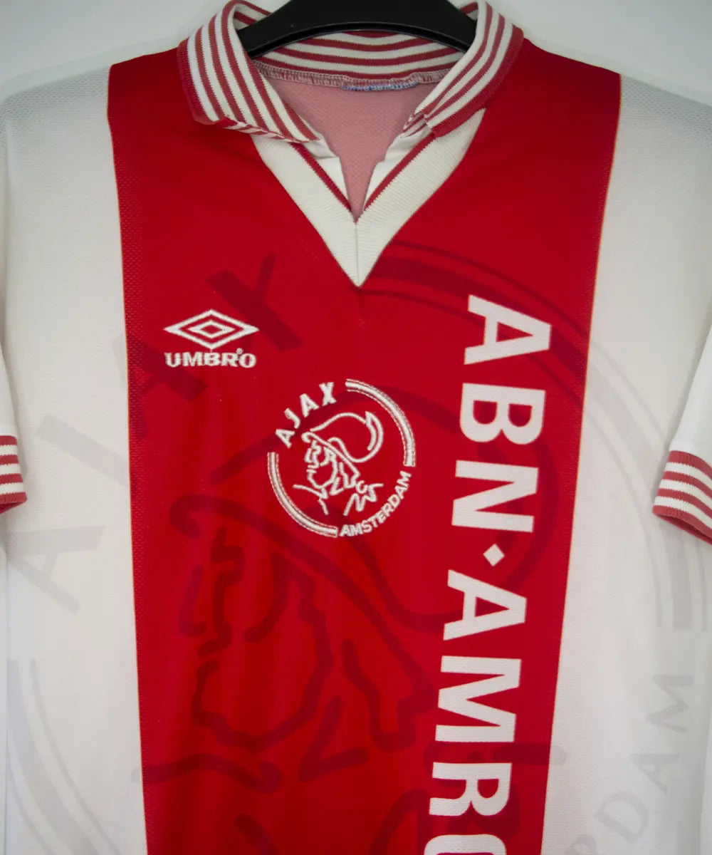 Maillot domicile de l'Ajax 1995-1996 de couleur rouge et blanc. On peut retrouver l'équipementier umbro et le sponsor ABN AMRO
