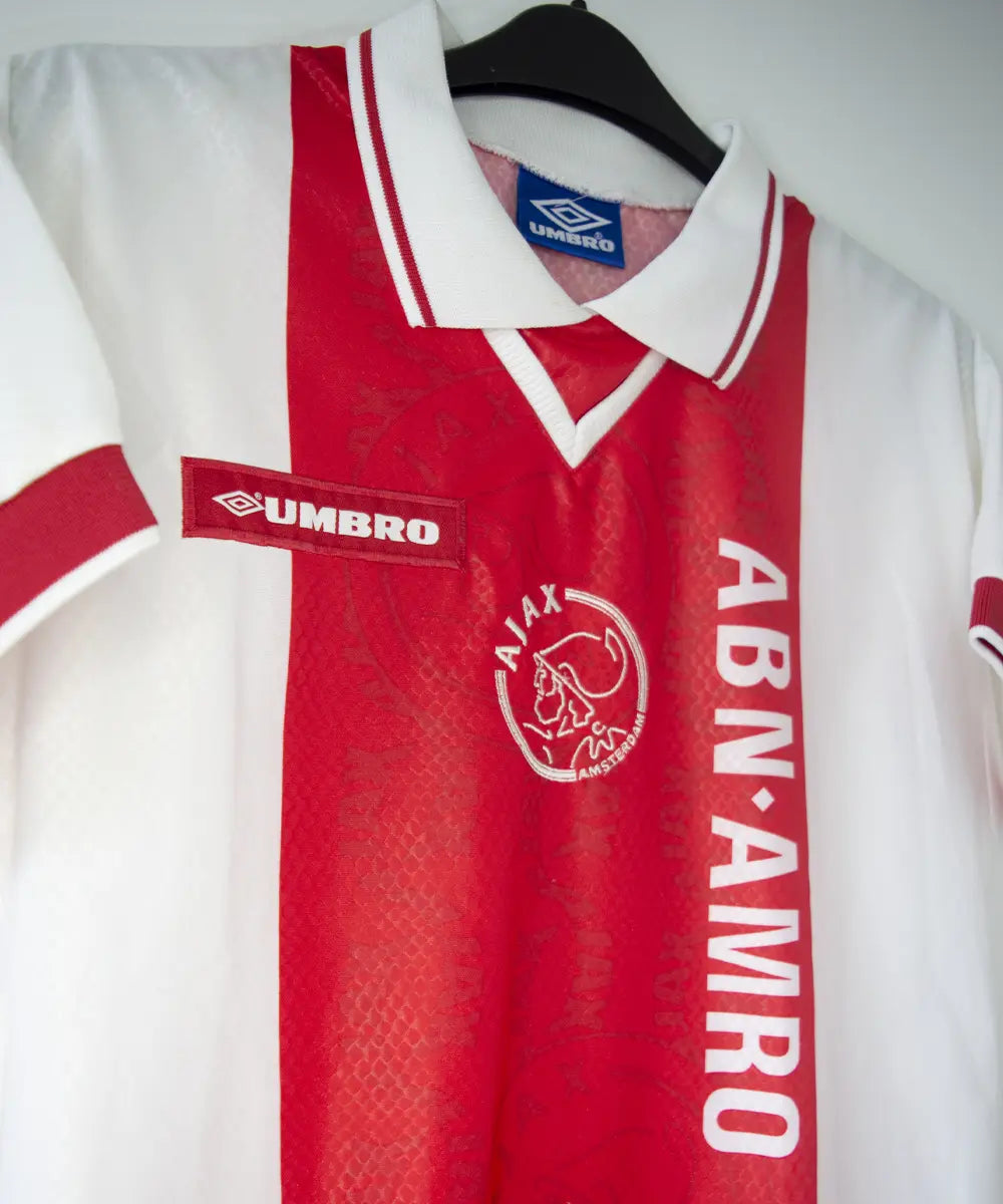 Maillot domicile de l'ajax de la saison 1998-1999 de couleur rouge et blanc. On peut voir l'équipementier umbro et le sponsor ABN AMRO