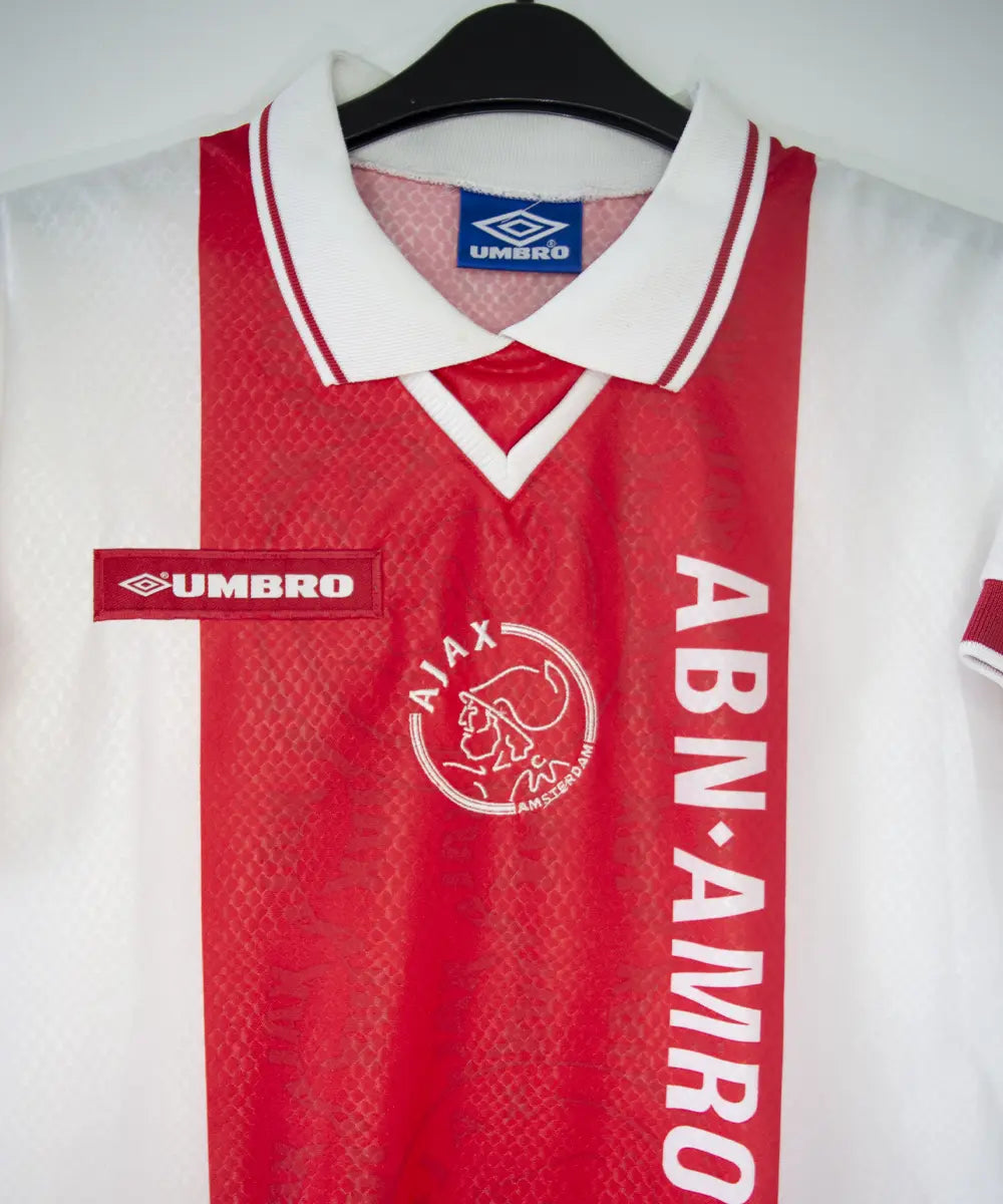 Maillot domicile de l'ajax de la saison 1998-1999 de couleur rouge et blanc. On peut voir l'équipementier umbro et le sponsor ABN AMRO