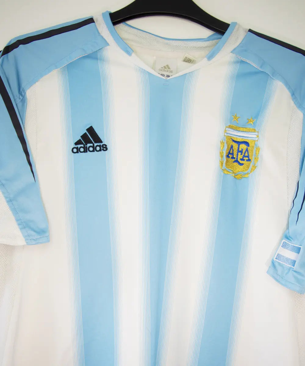 Maillot de foot authentique de l'argentine de la saison 2004-2005. Le maillot est de couleur bleu ciel et blanc. On peut retrouver l'équipementier adidas. Sur cette photo on peut voir le maillot de près