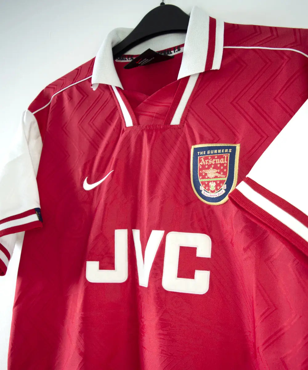 Maillot domicile d'arsenal de la saison 1996-1997 de couleur rouge et blanc. On peut retrouver l'équipementier nike et le sponsor JVC.