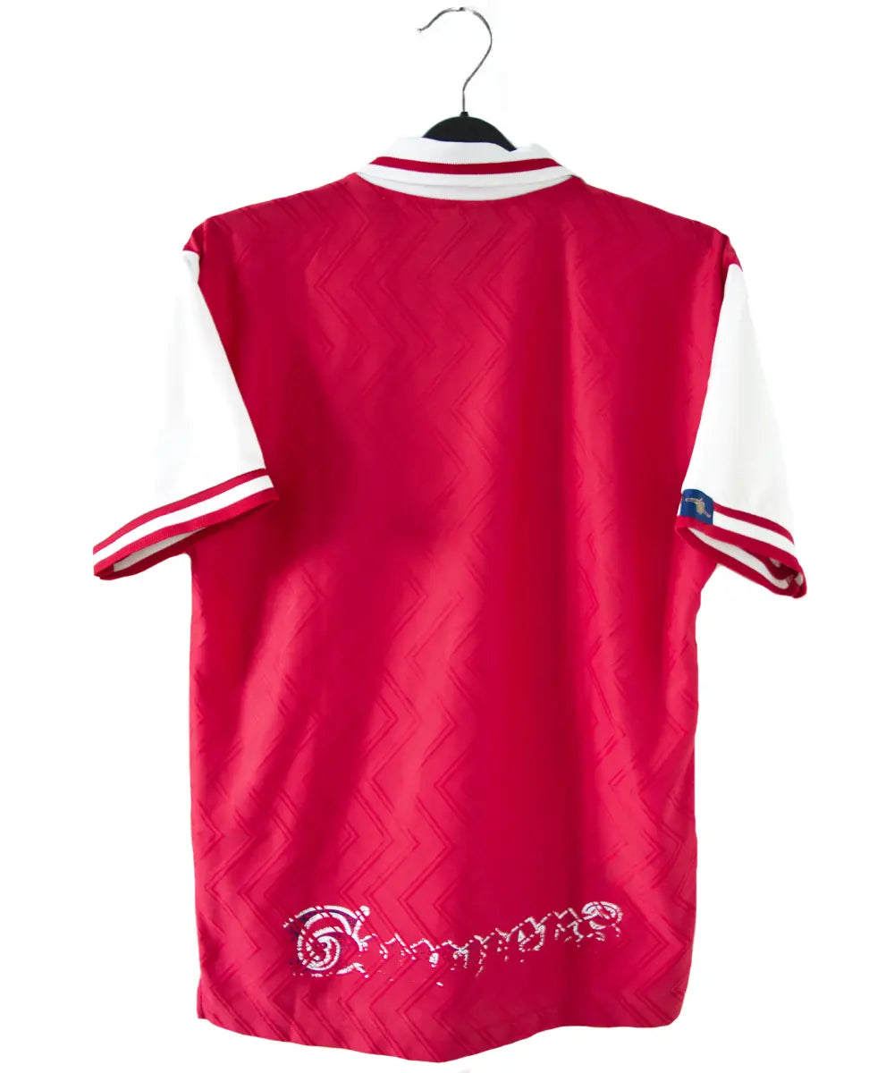 Maillot domicile d'arsenal de la saison 1996-1997 de couleur rouge et blanc. On peut retrouver l'équipementier nike et le sponsor JVC.