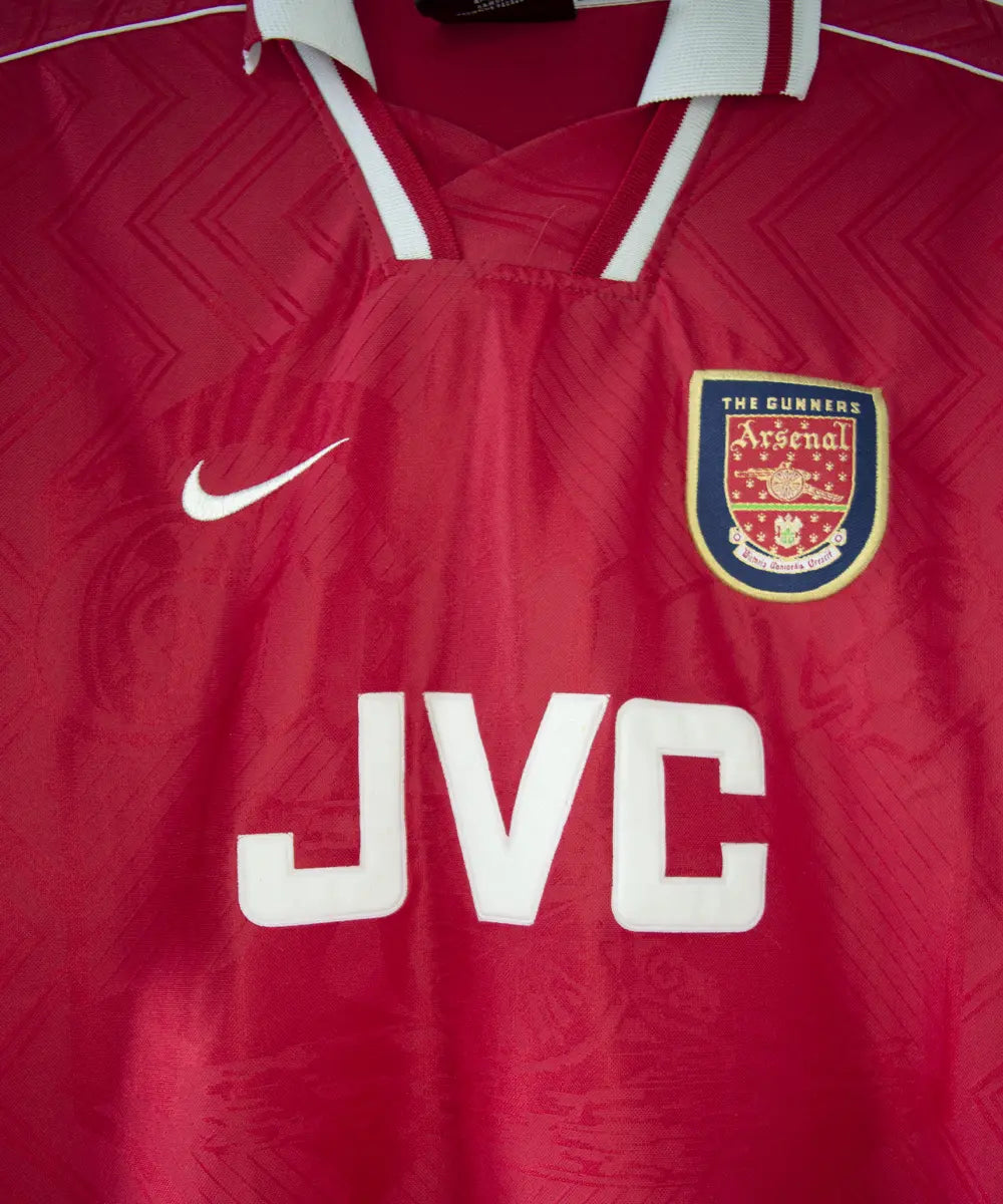 Maillot domicile d'arsenal de la saison 1996-1997 de couleur rouge et blanc. On peut retrouver l'équipementier nike et le sponsor JVC.