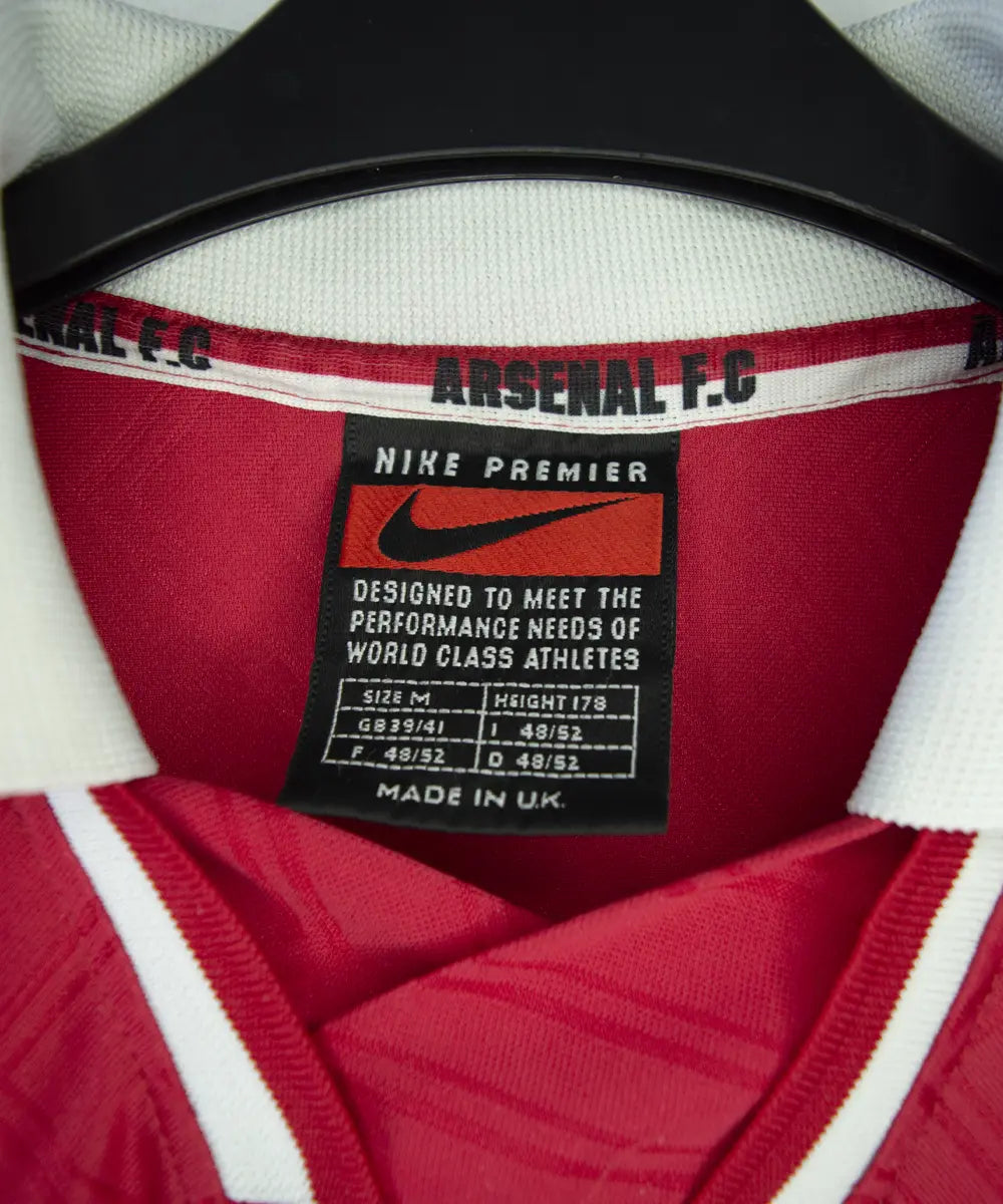 Maillot domicile d'arsenal de la saison 1996-1997 de couleur rouge et blanc. On peut retrouver l'équipementier nike et le sponsor JVC.
