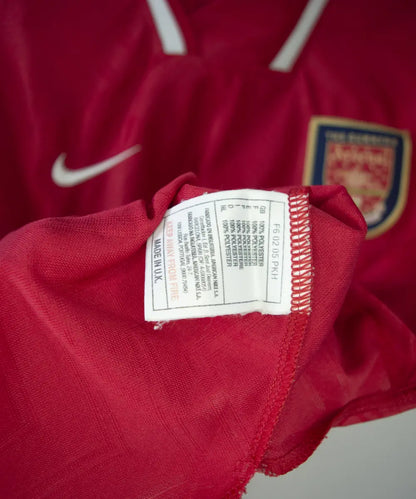 Maillot domicile d'arsenal de la saison 1996-1997 de couleur rouge et blanc. On peut retrouver l'équipementier nike et le sponsor JVC.