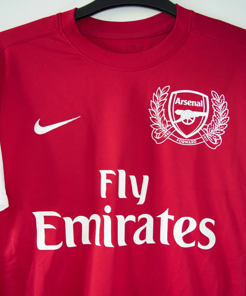 Maillot domicile d'Arsenal de la saison 2011-2012. On peut retrouver l'équipementier nike et le sponsor fly emirates. Le maillot est floqué du numéro 12 Thierry Henry