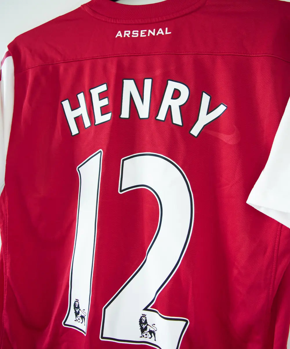 Maillot domicile d'Arsenal de la saison 2011-2012. On peut retrouver l'équipementier nike et le sponsor fly emirates. Le maillot est floqué du numéro 12 Thierry Henry