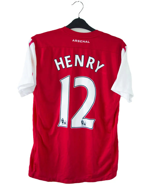 Maillot domicile d'Arsenal de la saison 2011-2012. On peut retrouver l'équipementier nike et le sponsor fly emirates. Le maillot est floqué du numéro 12 Thierry Henry