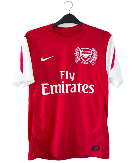 Maillot domicile d'Arsenal de la saison 2011-2012. On peut retrouver l'équipementier nike et le sponsor fly emirates. Le maillot est floqué du numéro 12 Thierry Henry
