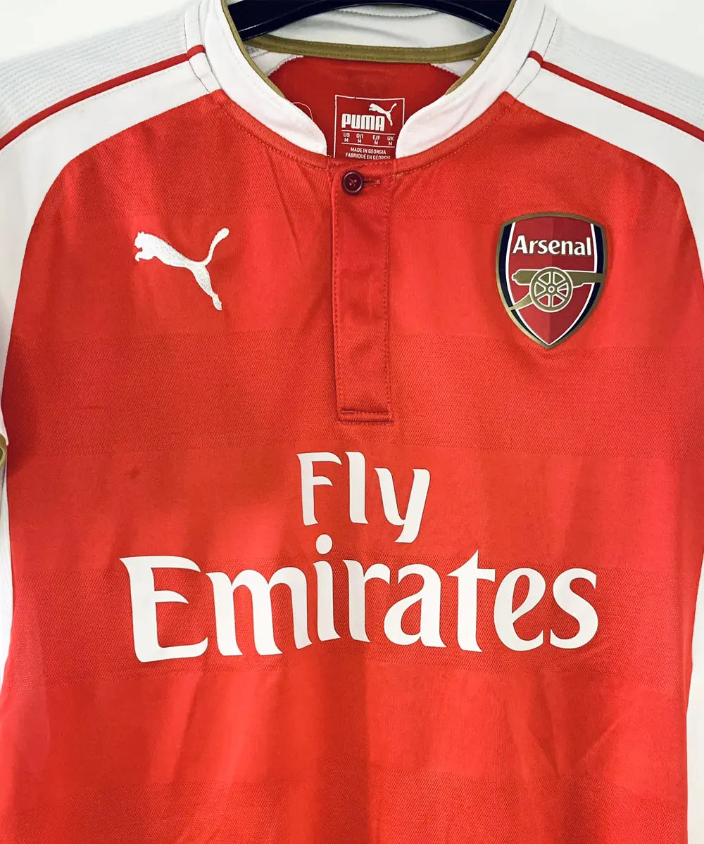 Maillot domicile vintage rouge et blanc d'Arsenal de la saison 2015-2016. On peut retrouver l'équipementier Puma et le sponsor fly emirates