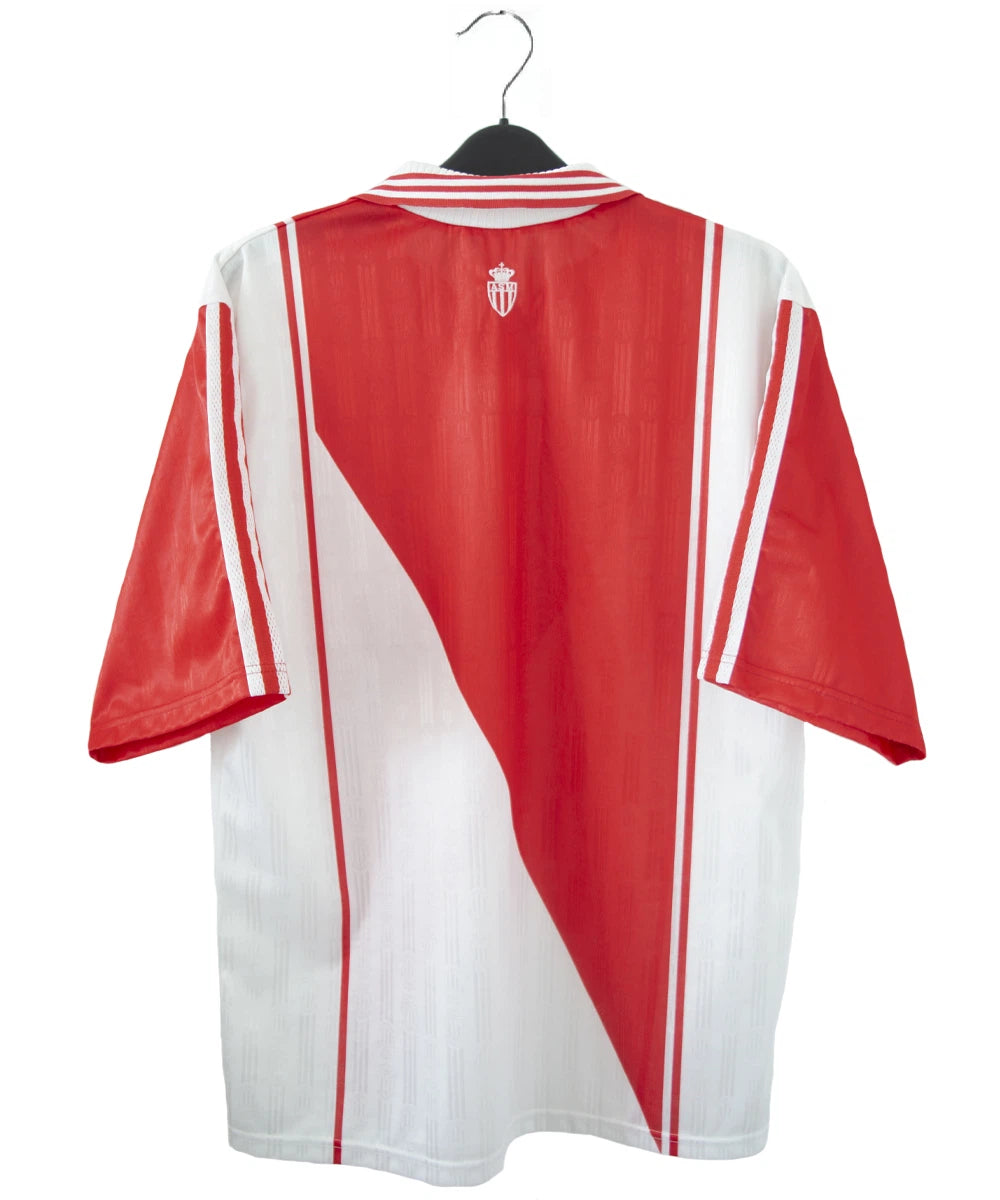 Maillot de foot vintage domicile rouge et blanc de l'AS Monaco de la saison 1996/1998. On peut retrouver l'équipementier adidas et le sponsor Eurest. Il s'agit d'un maillot authentique