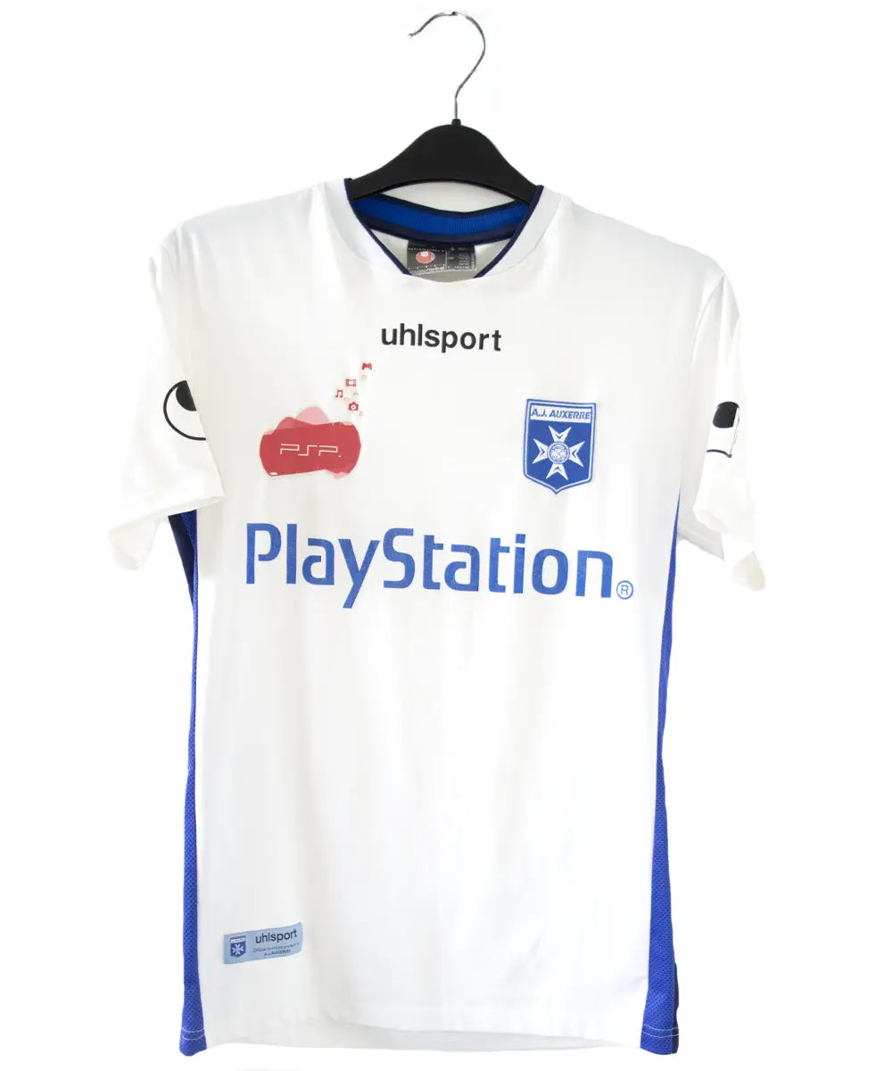 Maillot domicile de l'AJ Auxerre de couleur blanc et bleu. On peut retrouver l'équipementier uhlsport et les sponsors PSP et Playstation