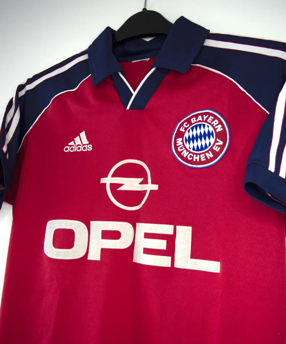 Maillot domicile rouge, bleu et blanc du bayern de la saison 1999-2001. On peut retrouver l'équipementier adidas et le sponsor opel