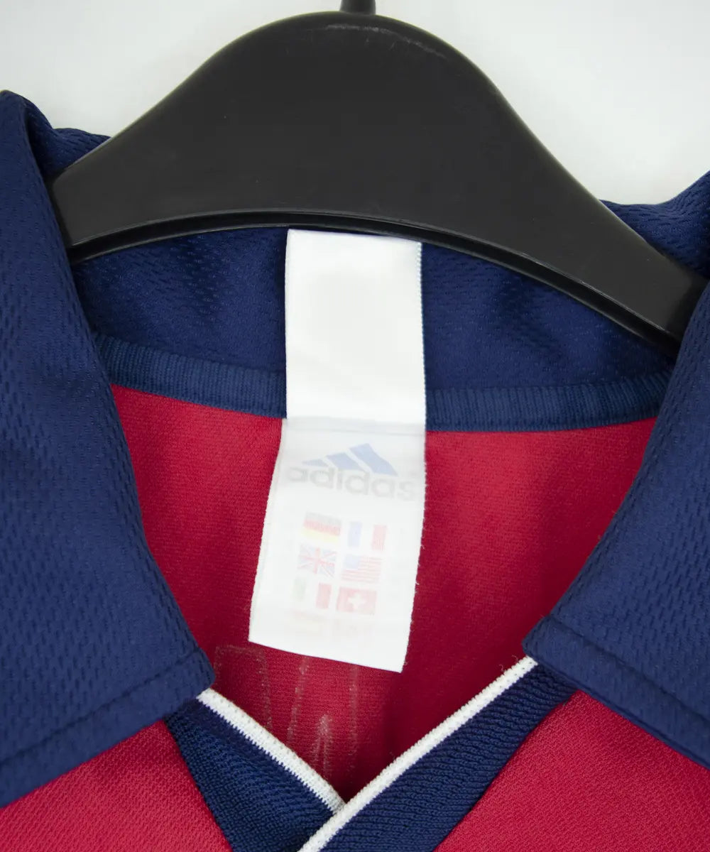 Maillot domicile rouge et bleu vintage du bayern munich de la saison 1999-2001. On peut retrouver l'équipementier adidas et le sponsor opel. Le maillot est floqué du numéro 9 Elber