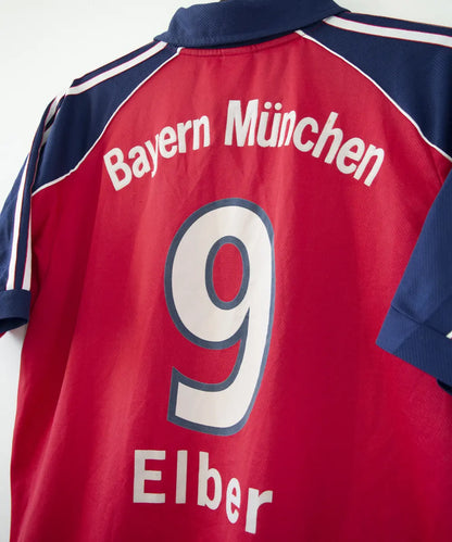 Maillot domicile rouge et bleu vintage du bayern munich de la saison 1999-2001. On peut retrouver l'équipementier adidas et le sponsor opel. Le maillot est floqué du numéro 9 Elber