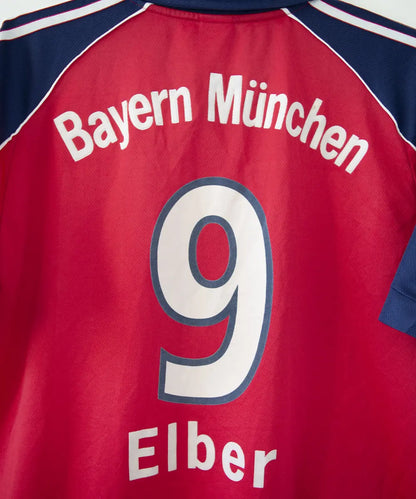 Maillot domicile rouge et bleu vintage du bayern munich de la saison 1999-2001. On peut retrouver l'équipementier adidas et le sponsor opel. Le maillot est floqué du numéro 9 Elber