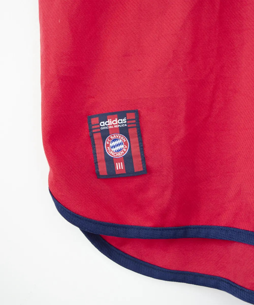 Maillot domicile rouge et bleu vintage du bayern munich de la saison 1999-2001. On peut retrouver l'équipementier adidas et le sponsor opel. Le maillot est floqué du numéro 9 Elber
