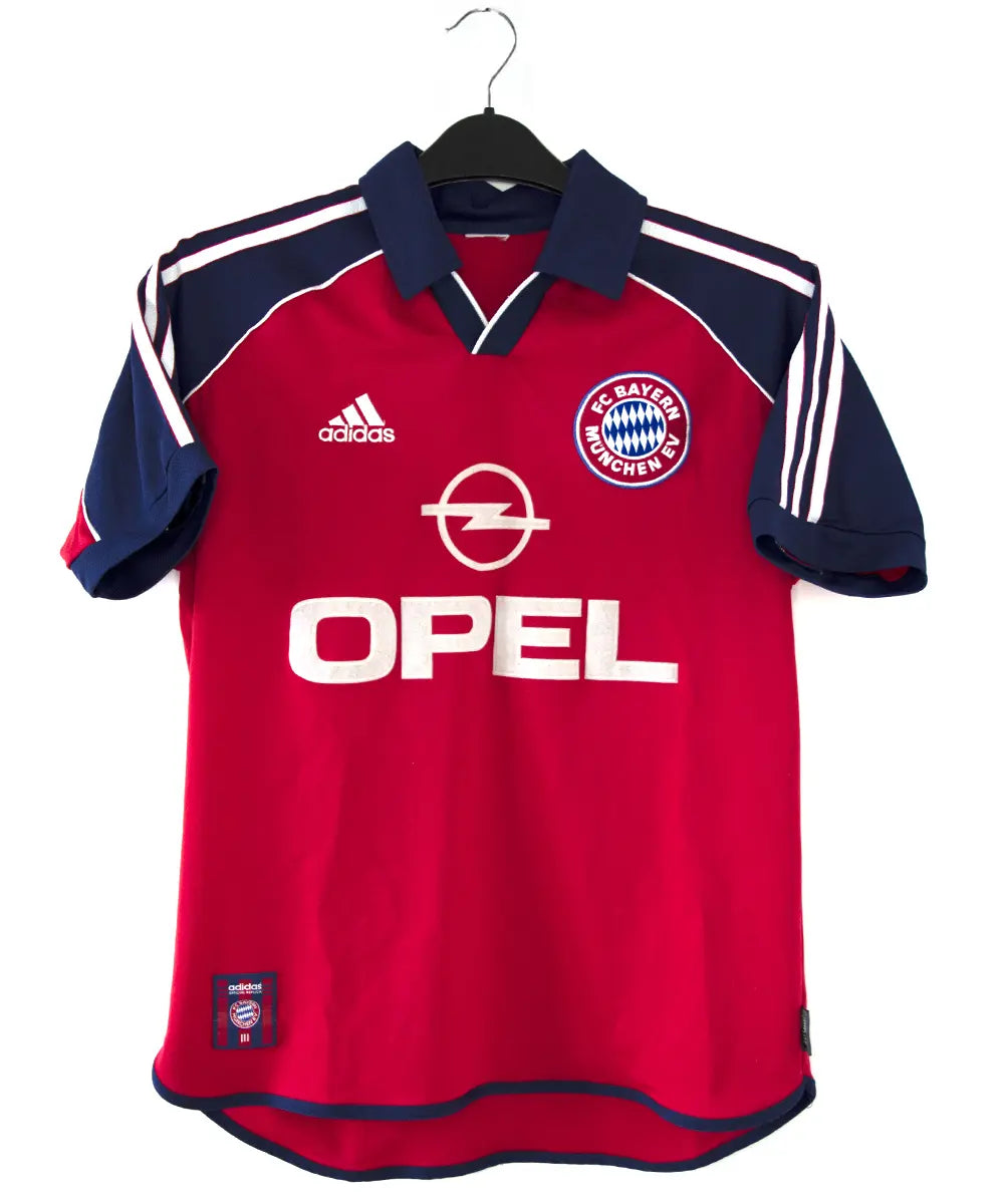 Maillot domicile rouge, bleu et blanc du bayern de la saison 1999-2001. On peut retrouver l'équipementier adidas et le sponsor opel