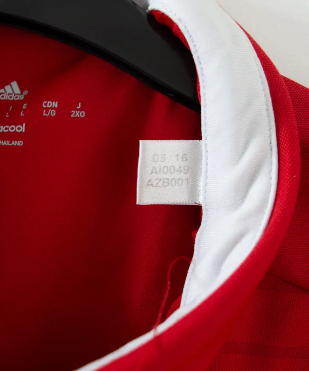 Maillot vintage domicile rouge et blanc du bayern munich de la saison 2016-2017. On peut retrouver l'équipementier adidas et le sponsor t. Sur cette photo on peut voir l'étiquette comportant les numéros AI0049